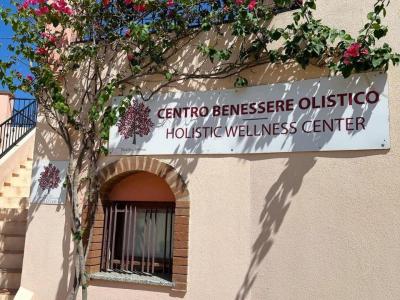 Centre de bien-être holistique avec fleurs colorées et ciel bleu.