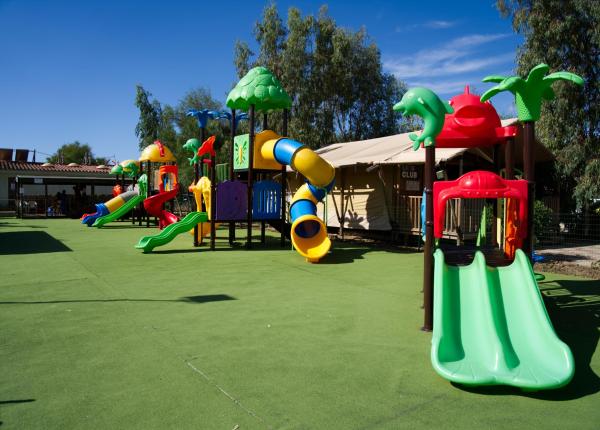 Parco giochi colorato con scivoli e strutture divertenti per bambini.