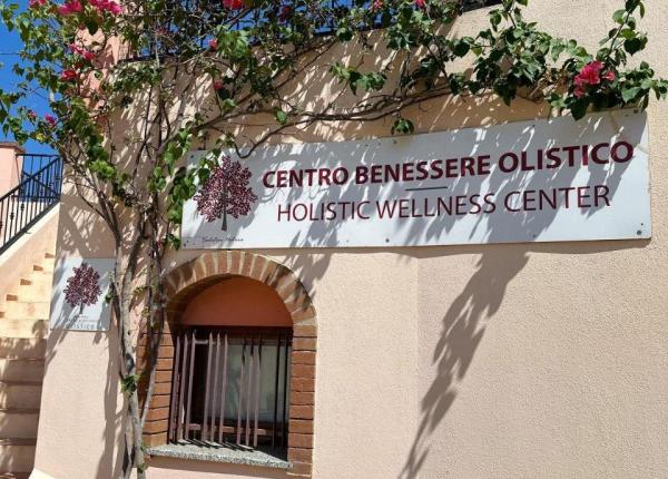 Centre de bien-être holistique avec fleurs colorées et ciel bleu.