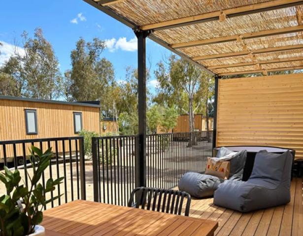 Terrasse mit Stühlen, Holztisch und Blick auf kleine Häuser.